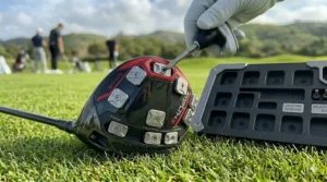 An open accessory kit containing various grams of individual interchangeable weights for a golf driver customization.