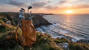 A premium golf iron set overlooking the dramatic coastline and ocean waves at a famous American championship course.