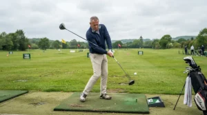 A senior golfer striking a tee shot with a modern senior golf driver for more distance at the driving range.